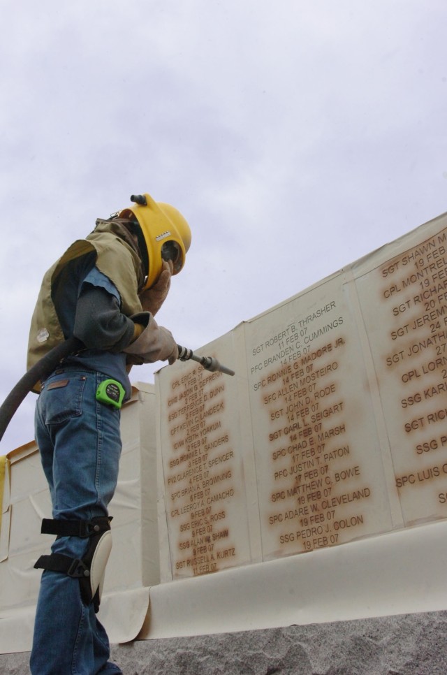 A Phipps Memorial associate who oversees production for the monument business Wayne Smith puts the finishing touches on the name engraving of Spc. Ronnie G. Madore Jr., at the 1st Cavalry Division's Operation Iraqi Freedom memorial located at Fort Ho...