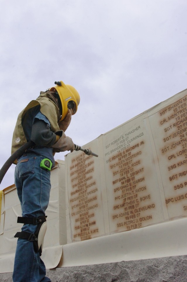 A Phipps Memorial associate who oversees production for the monument business Wayne Smith puts the finishing touches on the name engraving of Spc. Ronnie G. Madore Jr., at the 1st Cavalry Division's Operation Iraqi Freedom memorial located at Fort...