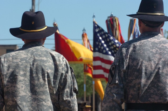 The outgoing top noncommissioned officer Command Sgt. Maj. Philip F. Johndrow (left) and the incoming deputy commanding general for support Brig. Gen. Frederick S. Rudesheim stand in front of the 1st Cavalry Division's parade field during a patch...
