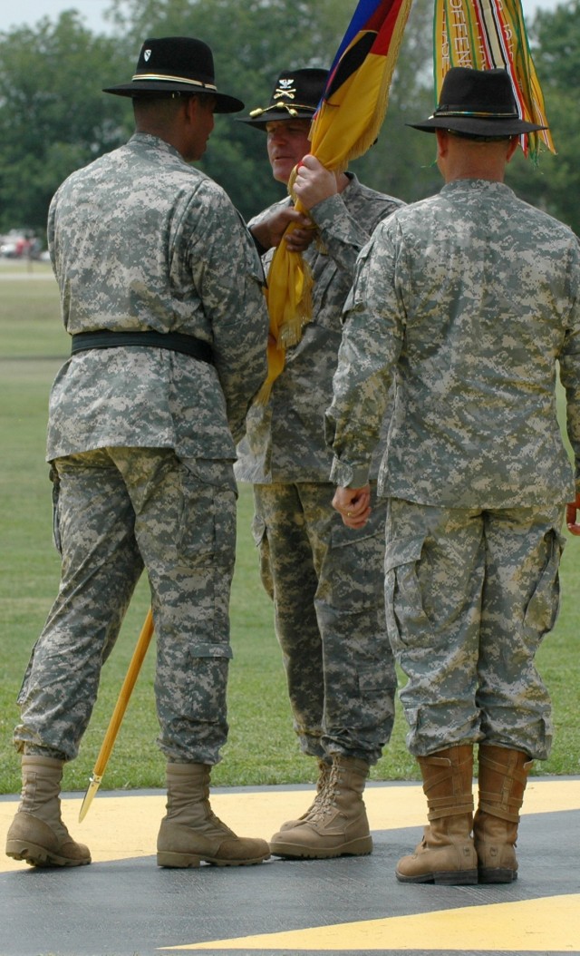 Brig. Gen. (P) Vincent K. Brooks (left), the commanding general of the 1st Cavalry Division, passes the 1st "Ironhorse" Brigade Combat Team guidon to incoming Ironhorse Brigade commander, Col. Tobin L. Green (center) as outgoing commander Col....