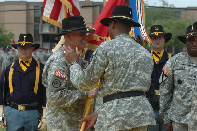 After handing the 1st "Ironhorse" Brigade, 1st Cavalry Division guidon to Col. Tobin L. Green, incoming commander, Brig. Gen. (P) Vincent K. Brooks, the commanding general of the division, gives Green, who has just accepted command of the...