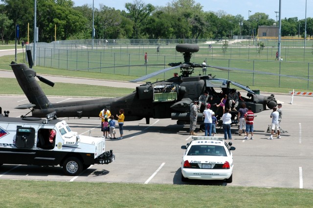 Pilots from 1st Battalion, 227th Aviation Regiment, 1st Air Cavalry Brigade, 1st Cavalry Division, talk to children and their parents about the capabilities of the AH-64D Apache attack helicopter, during a static display at the Killeen Community...