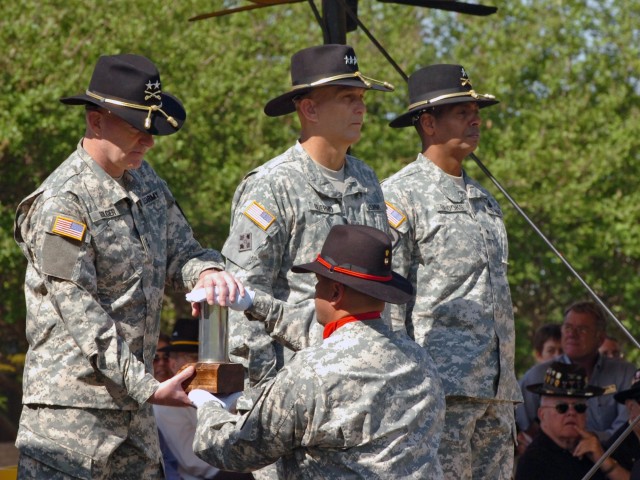 The new commanding general of the 1st Cavalry Division Maj. Gen. Daniel P. Bolger (left) of Aurora, Ill., receives the first round fired from a First Team Soldier during the his change of command ceremony held at Fort Hood, Texas', Cooper Field...