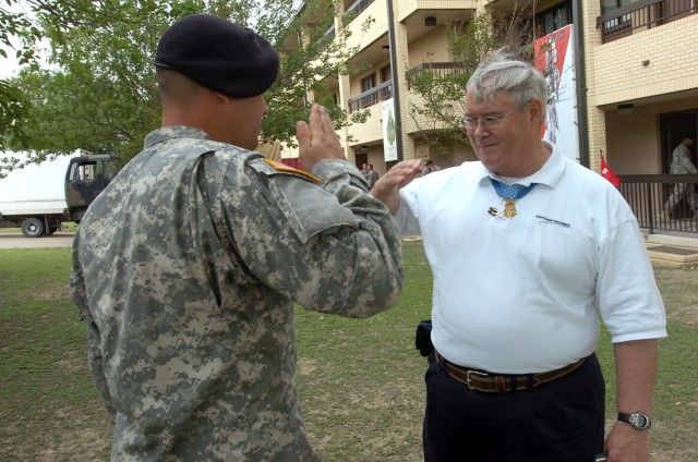 Medal of Honor recipient Charles Hagemeister salutes Spc. Jeremy Varnell, a medic from his former unit, Headquarters and Headquarters Company, 1st Battalion, 5th Cavalry Regiment, 2nd Brigade Combat Team, 1st Cavalry Division, during his visit with t...
