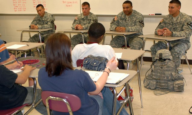 Answering questions, (from left to right) Sgt. Gabriel Santana, Spc. Robert Smith, Sgt. Marion DeBoe and Capt. Damasio Davila, Co. D, 1st Battalion, 12th Cavalry Regiment, 3rd Brigade Combat Team, 1st Cavalry Division, speak with an eighth grade...
