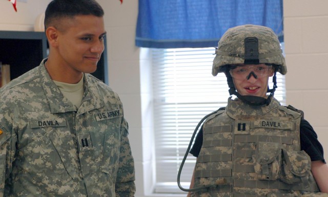 Evander Francis (right), an eighth grade student at Lamar Middle School, tries on the body armor of Capt. Damasio Davila, commander of Co. D, 1st Battalion, 12th Cavalry Regiment, 3rd Brigade Combat Team, 1st Cavalry Division, during a journalism...