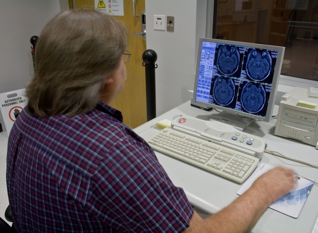 Ronnie Hunter, the chief technician of the research center's General Electric 3-Tesla Signa Excite Scanner and a 1968-1970 Vietnam combat veteran, scans the brain of a 4th Brigade Combat Team, 1st Cavalry Division, Soldier at the University of Texas ...