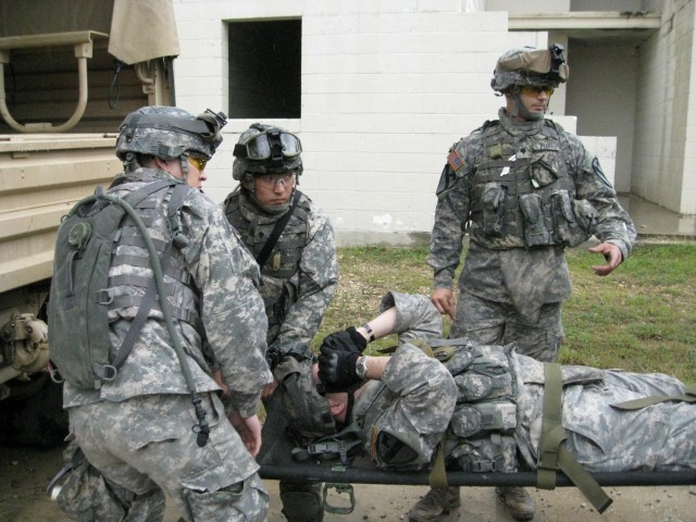 Spc. Brian Pratt (right), of Dayton, Ohio, gives a class on litter carrying and loading a vehicle during the Medical platoon training exercise at the Elijah Military Operations on Urbanized Terrain Site, May 5 and 6. Spc. Andrew Chung (middle), of...