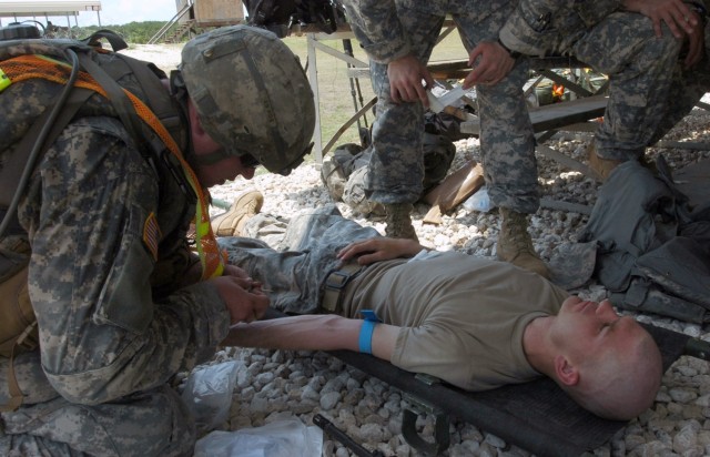 Knoxville, Tenn. native, Spc. Joe Ankenbauer, prepares to administer an IV to Spc. Joshua Walston of Paradise, Texas during The Bushmaster PT Competition held at North Fort Hood May 28. Both Soldiers are assigned to Company B, 1st Battalion, 5th...