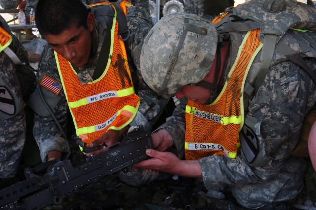 Pfc. Jose Bautista, a native of San Diego helps Spc. Joe Ankenbauer reassemble an M-240 Pfc. Jose Bautista, a native of San Diego, helps Spc. Joe Ankenbauer, originally from Knoxville, Tenn.  reassemble an M-240 during the Bushmaster PT...