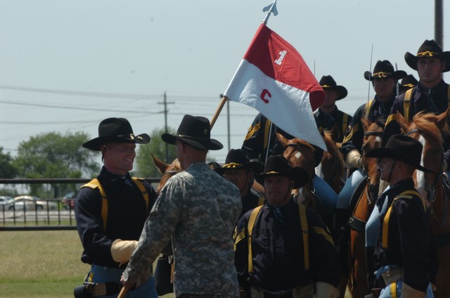 The incoming commander of the 1st Cavalry Division's Horse Cavalry Detachment Capt. Jay Bunte (left) assumes responsibility from Capt. Ted Zagraniski (right) through the Division Special Troops Battalion commander Lt. Col. Matthew Karres (center) dur...