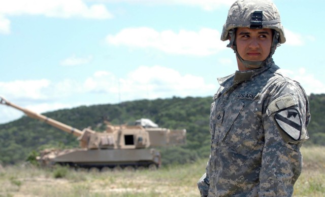 Pfc. Jose A. Hercules, a field artillery crewman from Miami, Fla. with Battery B, 2nd Battalion, 82nd Field Artillery Regiment, 3rd Brigade Combat Team, 1st Cavalry Division, observes from a distance as shots are fired from an M109A6 Paladin at...