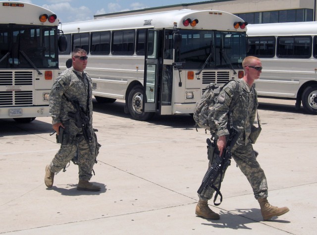 Sgt. Steven Robinson, a native of Barre, Maine, and Spc. Brandon Donaldson, a native of Jacksonville, Texas, walk from a bus to the Robert Gray Army Airfield deployment center on Fort Hood, Texas June 10. The Soldiers are members of the Long Knife...