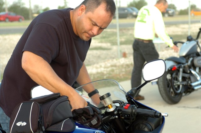 Killeen, Texas native Sgt. 1st Class Erick Cox, first sergeant for Troop A, 1st squadron, 7th Cavalry Regiment inspects his bike during the motorcycle inspection prior to the Ironhorse Bike Stampede June 12.  The stampede was a mentorship ride...