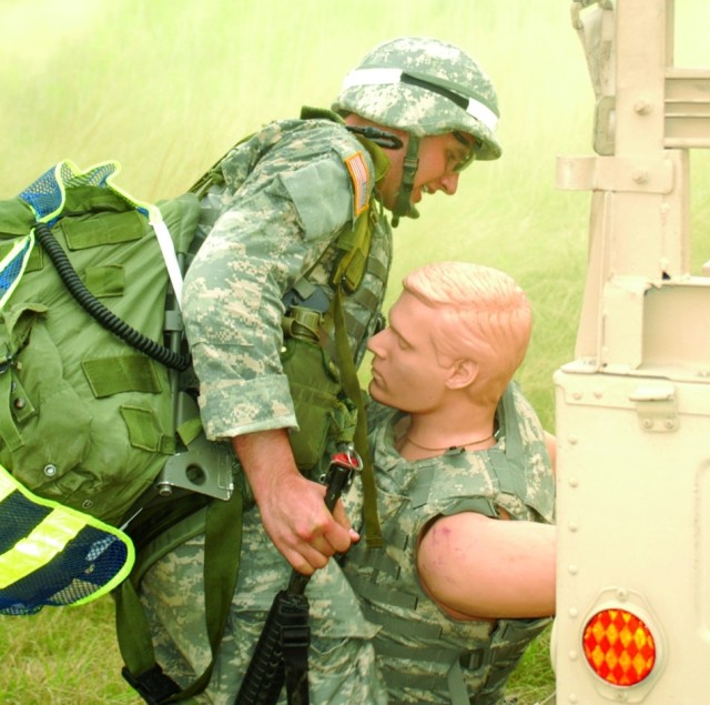 Spc. Daniel Farrier, MEDCOM Soldier of the Year, rescues a mannequin from a damaged vehicle during the combat scenario portion of the competition.
