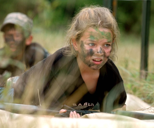 A girl low crawls while maintaining control of her "weapon" as part of the 6th Squadron, 9th Cavalry Regiment, 3rd Brigade Combat Team, 1st Cavalry Division's kid friendly Saber Spur Ride June 20 on Fort Hood, Texas. The child is performing the...