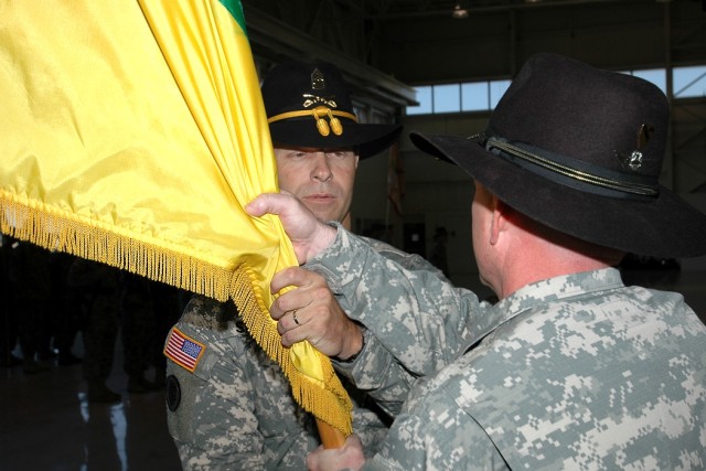 Sutter Creek, Calif., native Command Sgt. Maj. Scott Spiva (left), outgoing command sergeant major of the 1st Air Cavalry "Warrior" Brigade, 1st Cavalry Division, passes the brigade guidon to Cleveland, native Col. Douglas Gabram (right), commander o...