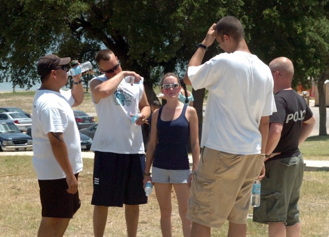 Soldiers from 1st Battalion, 7th Cavalry Regiment, 1st Brigade Combat Team, 1st Cavalry Division, and their families cooled off with water before taking to the field for a softball game. The event was part of the unit's early Independence Day...