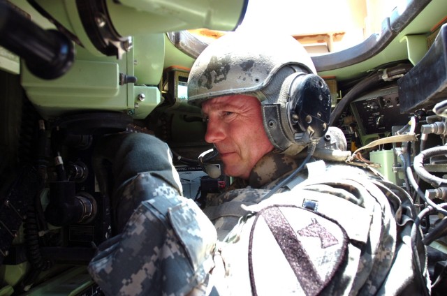 Colonel Douglas Gabram, commander of the 1st Air Cavalry "Warrior" Brigade, 1st Cavalry Division, who normally flies through the air in an AH-64D Apache attack helicopter, adjusts to the cockpit of the an M2A3 Bradley during an air/ground...