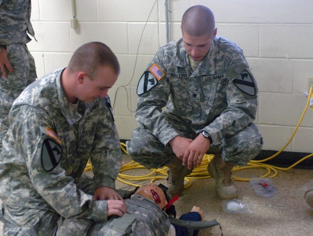 Cabool, Mo. native, Spc. Michael Bittle, removes the flack vest from the "casualty" as Seattle, Wash. native,  Spc. Matthew Keller looks on. Both Soldiers are part of Headquarters and Headquarters Company, 1st BSTB, 1st Cav. Div.. Keller coaches Bitt...