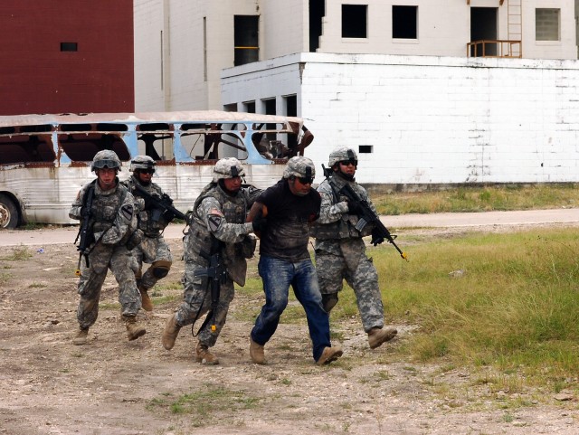 Cavalry scouts from Troop B, 4th Squadron, 9th Cavalry Regiment, 2nd Brigade Combat Team, 1st Cavalry Division, evacuate from a building with a simulated insurgent cell leader in custody during an air assault training operation dubbed "Operation...