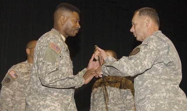 Lt. Gen. Robert Wilson, right, passes the noncommissioned officer sword to Command Sgt. Major John M. Gaines Jr.