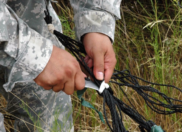 Sgt. Enrique Alvarado, a driver with the 15th Sustainment Brigade, 1st Cavalry Division cuts the ties of a parachute attached to supplies dropped by air for Co. D, 3-8 Cav., 3rd BCT, 1st Cav. Div., on Fort Hood, July 16.  3rd BCT is training for thei...