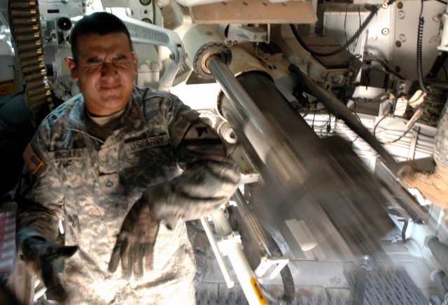 Pfc. Jose Hercules, a gunner with Battery A, 2nd Battalion, 82nd Field Artillery Regiment, 3rd Brigade Combat Team, 1st Cavalry Division from Miami, Fla., reacts to pulling the firing mechanism of an M109A6 155mm Paladin system July 16. 3rd BCT is...