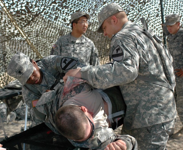 Spc. Lashonda Sparks (left), from Charlotte, N.C., and Spc. John Allen (right), from Long Beach, Calif., search for any hidden wounds on a casualty as part of a training exercise on Fort Hood July 21. Both medics, assigned to C Company, 215th...