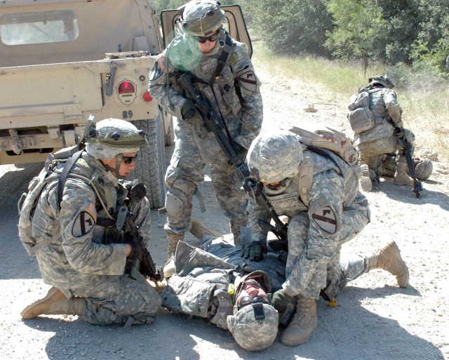 Three Soldiers treat a casualty as part of a training scenario simulating an Improvised Explosive Device attack on a convoy July 21. C Co., 215th Brigade Support Battalion, 3rd Brigade Combat Team, 1st Cavalry Division, the brigade's medic company, d...
