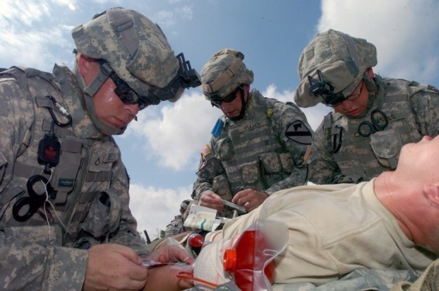 Pfc. Adam Bigelow (left), of Phoenix, Ariz.and Spc. Mark Fuller, of Waterbury, Conn., and Pfc. Mark Daniels, of Wayne, W.V., work on a casualty during 4th Squadron, 9th Cavalry Regiment, 2nd Brigade Combat Team, 1st Cavalry's Air MEDEVAC at the...