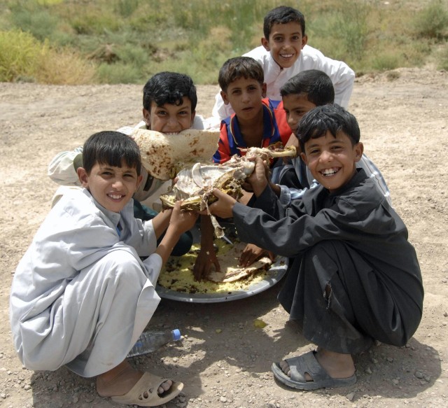 Iraqi children enjoy a plate of rice and lamb while more than 500 sheikhs from across the southern region of Iraq meet to discuss upcoming election and tribal issues. The sheikhs also met with leaders from the 2nd Sqdn., 12th Cav. Regt.,4th  BCT, 1st...