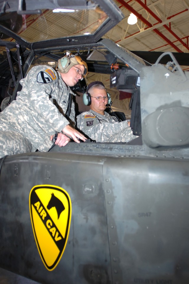 Biloxi, Miss., native Sgt. Derek Cranford (left), an armament specialist for Company D, 1st "Attack" Battalion, 227th Aviation Regiment, 1st Air Cavalry Brigade, explains the Target Acquisition Designation Sight on an AH-64D Apache attack...
