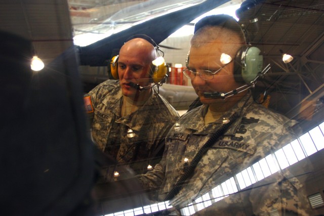 Hesperia, Calif., native Spc. Joseph Baker (left), an armament specialist for Company D, 1st "Attack" Battalion, 227th Aviation Regiment, 1st Air Cavalry Brigade, 1st Cavalry Division, shows Command Sgt. Maj. Rory Malloy (right), command sergeant...