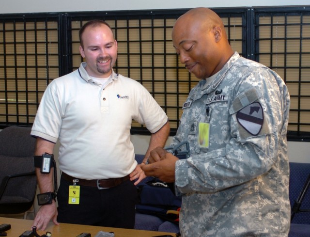 While examining the equipment for the V-Communicator Mobile device, Atmore, Ala. native, Sgt. 1st Class Thomas Poindexter (right), senior common ground station operator for Company B, Division Special Troops Battalion, 1st Cavalry Division, speaks to...