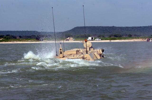 Soldiers from Headquarters and Headquarters Company, 1st Brigade Special Troops Battalion, 1st Brigade Combat Team, 1st Cavalry Division, thrust forward during a training exercise to test their M93 "Fox" vehicle at Blora Lake, Texas on July 31.  The ...