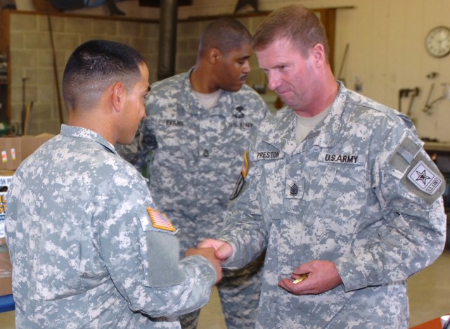 Taking the opportunity to meet with and talk to 1st Cavalry Division Soldiers, Sgt. Maj. of the Army Kenneth O. Preston (right) presents a coin to El Centro, Calif. native Pvt. John Preece, a tanker with Company D, 3rd Battalion, 8th Cavalry Regiment...