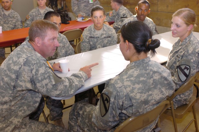 While taking time to speak with 1st Cavalry Division Soldiers, Sgt. Maj. of the Army Kenneth O. Preston (left) answers a question posed by Thedford, Neb. native Spc. Julianna Schaeffer (far right), a radio operator/maintainer for Company B, 3rd Briga...