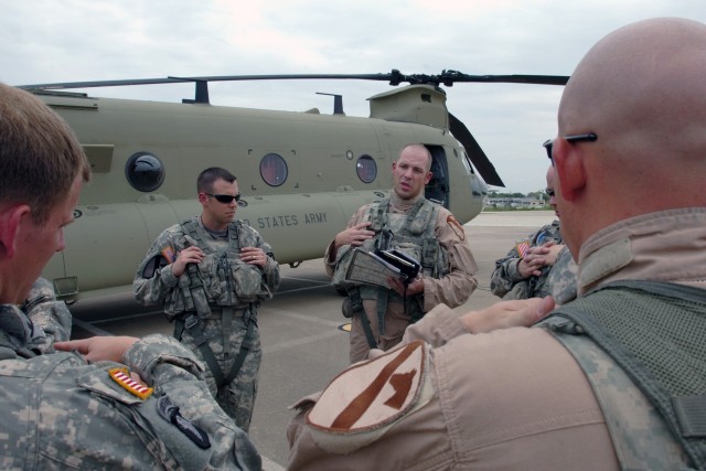 Capt. Kevin Consedine (left), a CH-47F Chinook pilot and commander of Company B, 2nd Battalion, 227th Aviation Regiment, 1st Air Cavalry Brigade, 1st Cavalry Division, listens to the pre-flight brief given by Midland, Mich., native Chief Warrant Offi...