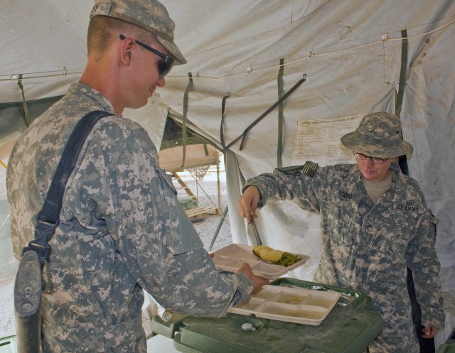 Private Susan Young, an Army cook, assigned to Co. E, 27th BSB, loads Pvt. Arron Riley's plate with food the morning of Aug. 2. Riley an infantryman from Wukalla, Fla., is assigned to 2nd Sqdn, 7th Cav. Regt. The Soldier-cooks assigned to Co. E provi...