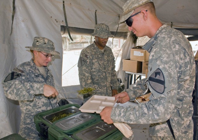 Private Susan Young, an Army cook assigned to Co. E, 27th BSB, loads Pvt. Arron Riley's plate with food the morning of Aug. 2. Riley an infantryman from Wukalla, Fla., is assigned to 2nd Sqdn., 7th Cav. Regt. The Soldier-cooks assigned to Co. E prepa...