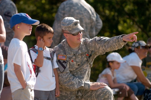 Capt. Tyler Donnel, Battery B commander, points out the Paladin to 9-year-old Bryson Thacker (left) and his son, 7-year-old Devin during the 3rd Battalion, 82nd Field Artillery Regiment, 2nd Brigade Combat Team, 1st Cavalry Division's family day...