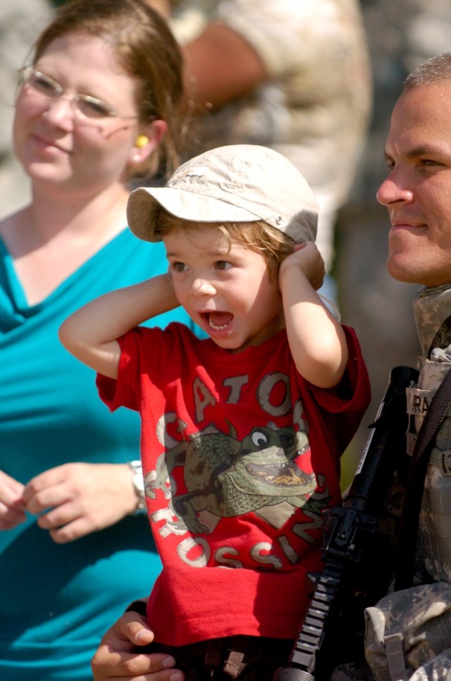Three-year-old Elias Pratt plugs his ears to the M109 Paladin's blast as he watches with his parents Nina and WO1 David Pratt of Tucson, Ariz. during the 3rd Battalion, 82nd Field Artillery Regiment, 2nd Brigade Combat Team, 1st Cavalry Division's...