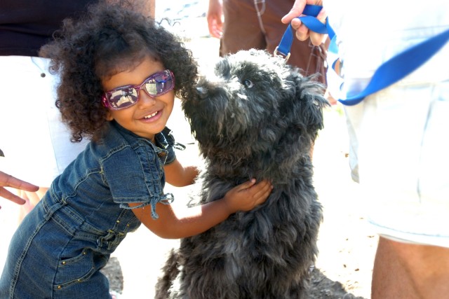 One way to stay cool amidst the Texas heat is to look cool. Yazzabel Ramirez, 2, gives dog, Sasha-Mishka ('bear cub' in Russian), a hug during an organizational day put on by 1st "Attack" Battalion, 227th Aviation Regiment, 1st Air Cavalry...