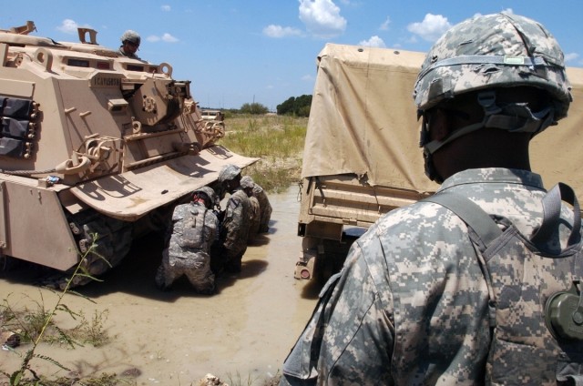 Chief Warrant Officer 2 Andre Dart, an Allied Trades technician in the Service and Recovery Shop, Company B, 15th Brigade Support Battalion, 2nd Brigade Combat Team, 1st Cavalry Division of Brunswich, Ga., watches an M88A2 Hercules Recovery Vehicle d...