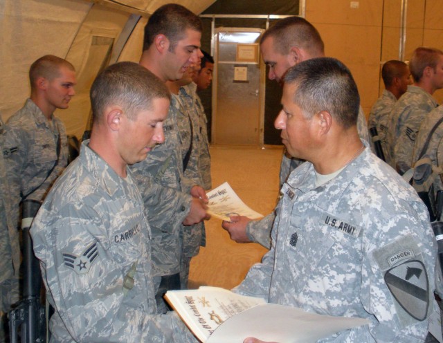 Command Sergeant Major George Zamudio, the enlisted leader of the 2nd Bn., 7th Cav. Regt., 4th BCT, 1st Cav. Div., and Lt. Col. Edward Bohnemann, the commander of the 2nd Bn., 7th Cav. Regt., issue combat spurs as thanks to the 25 Airmen of the...