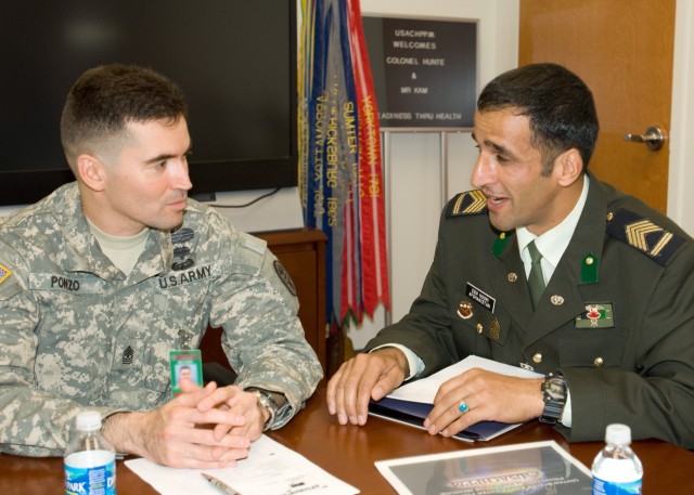 Afghan medical CSM and CHPPM Sgt. Maj. Osvaldo discuss preventive medicine measures.