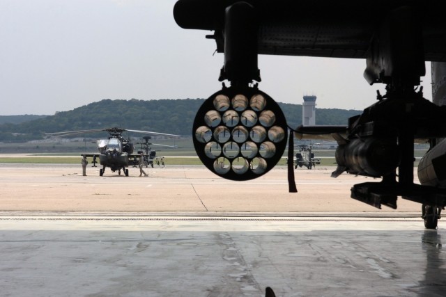 A typical view from the hangar - crew chiefs from 1st "Attack" Battalion, 227th Aviation Regiment, 1st Air Cavalry Brigade, 1st Cavalry Division, prepare an AH-64D Apache attack helicopter for flight at Robert Gray Army Air Field, Fort Hood,...