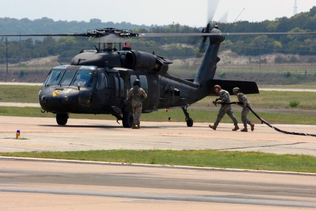 Soldiers from 4th "Guns" Battalion, 227th Aviation Regiment, 1st Air Cavalry Brigade, 1st Cavalry Division, refuel a UH-60 Black Hawk from 3rd "Spearhead" Battalion, 227th Aviation Regiment, 1st ACB, during flight operations at Robert Gray Army...