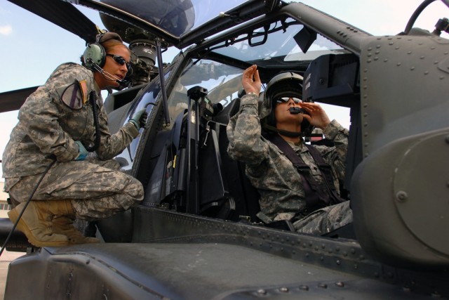 Phoenix native Spc. Elodia May (left), an AH-64D Apache attack helicopter crew chief for 1st "Attack" Battalion, 227th Aviation Regiment, 1st Air Cavalry Brigade, 1st Cavalry Division, talks to fellow crew chief and Shawano, Wis., native Spc....